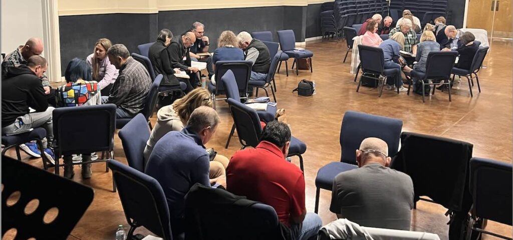 clusters of people in chairs praying